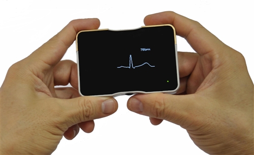 Handheld Micro ECG device displaying a heart signal.